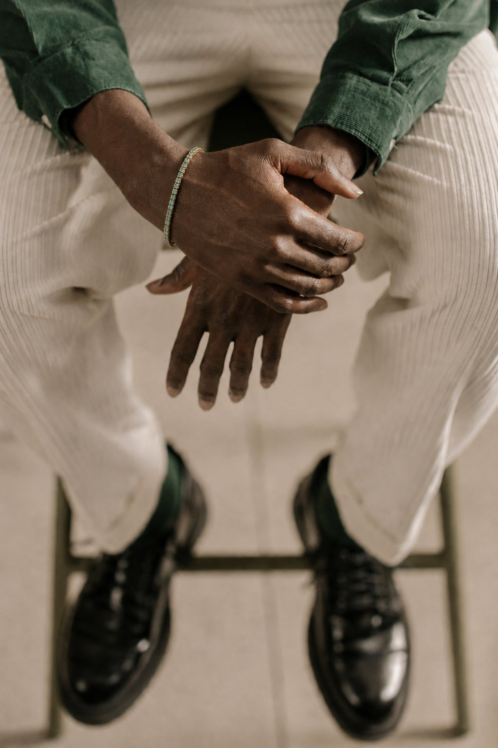 Homem usando pulseira dourada Riviera Zircônia Doré com camisa verde