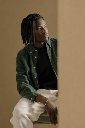 Homem com camisa verde usando pulseira Riviera Aspen Esmeralda