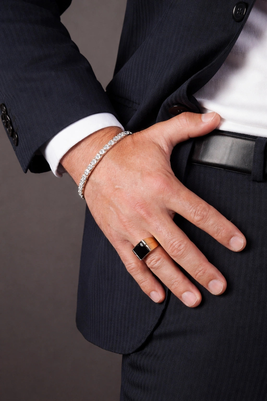Detalhe da pulseira Riviera Topázio Sky no pulso com traje social