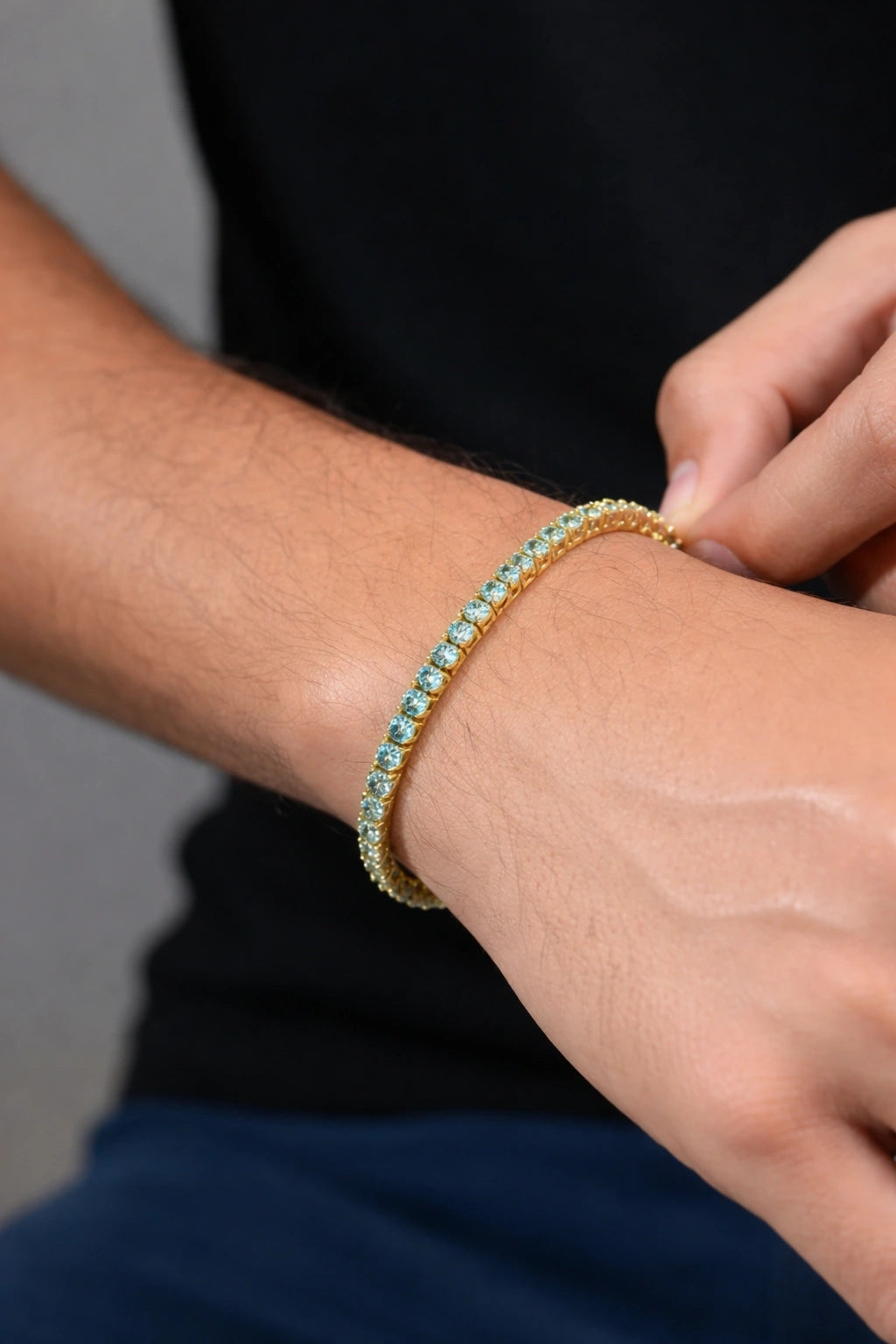 Detalhe da pulseira dourada Riviera Zircônia Doré sendo ajustada no pulso