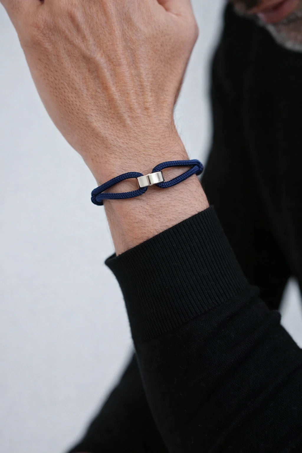 Pulseira Milan azul no pulso de homem com blusa preta