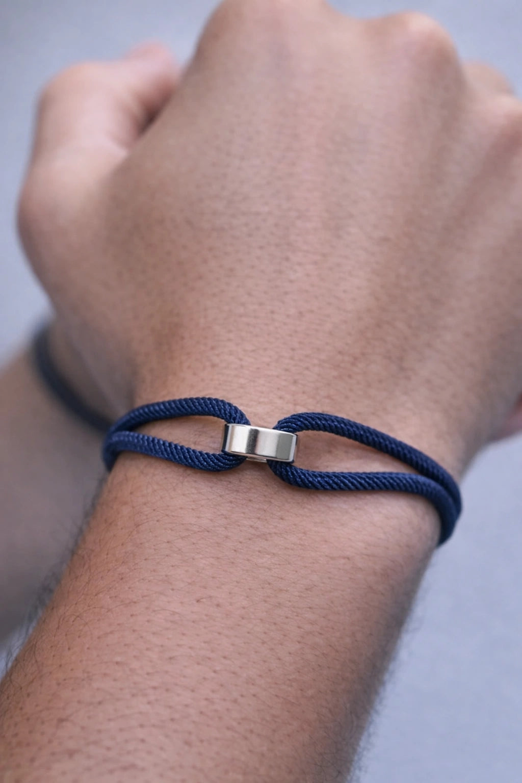 Close da pulseira Milan azul com elemento central prateado no pulso