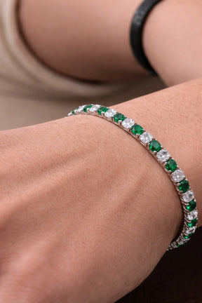 Close da pulseira Aspen Esmeralda com pedras verdes e claras no pulso