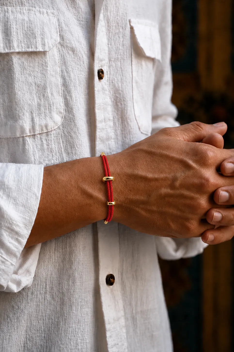 Pulseira Genebra vermelha de corda no pulso com camisa branca