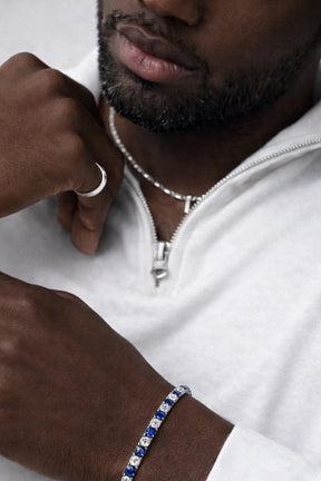 Homem com roupa branca usando pulseira azul Riviera Aspen Marine