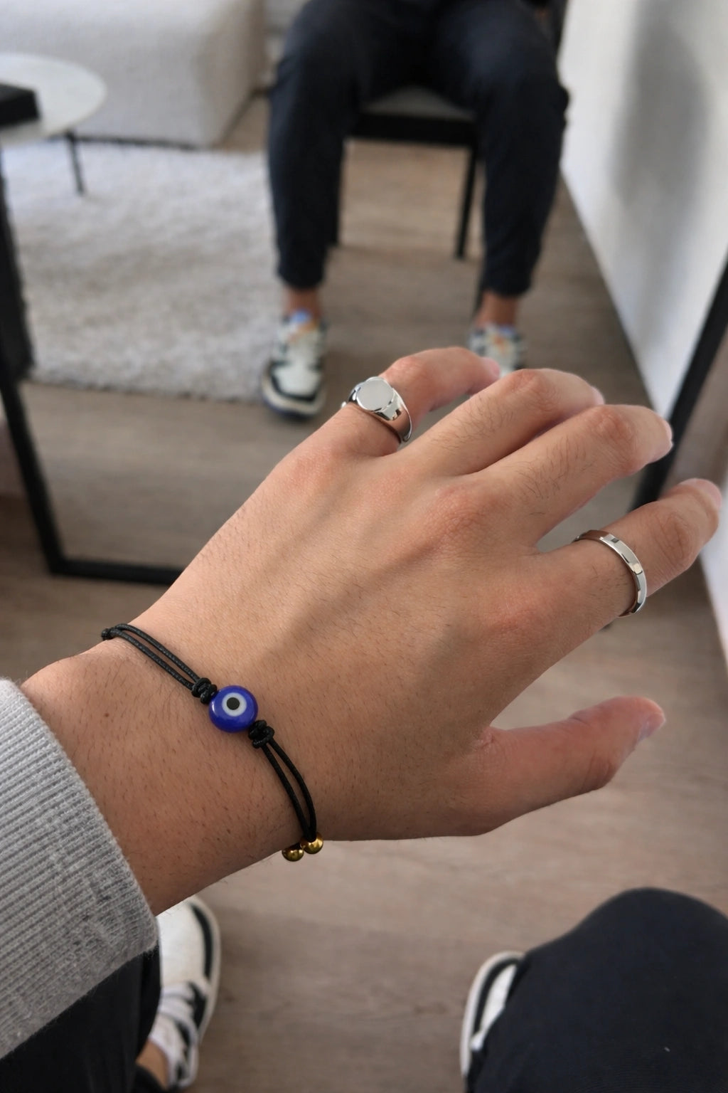 Homem usando pulseira de corda preta com olho grego