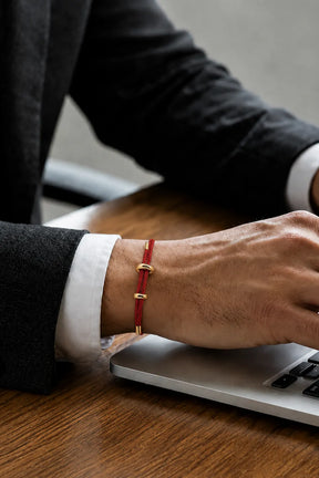 Pulseira masculina de corda vermelha usada com terno no trabalho