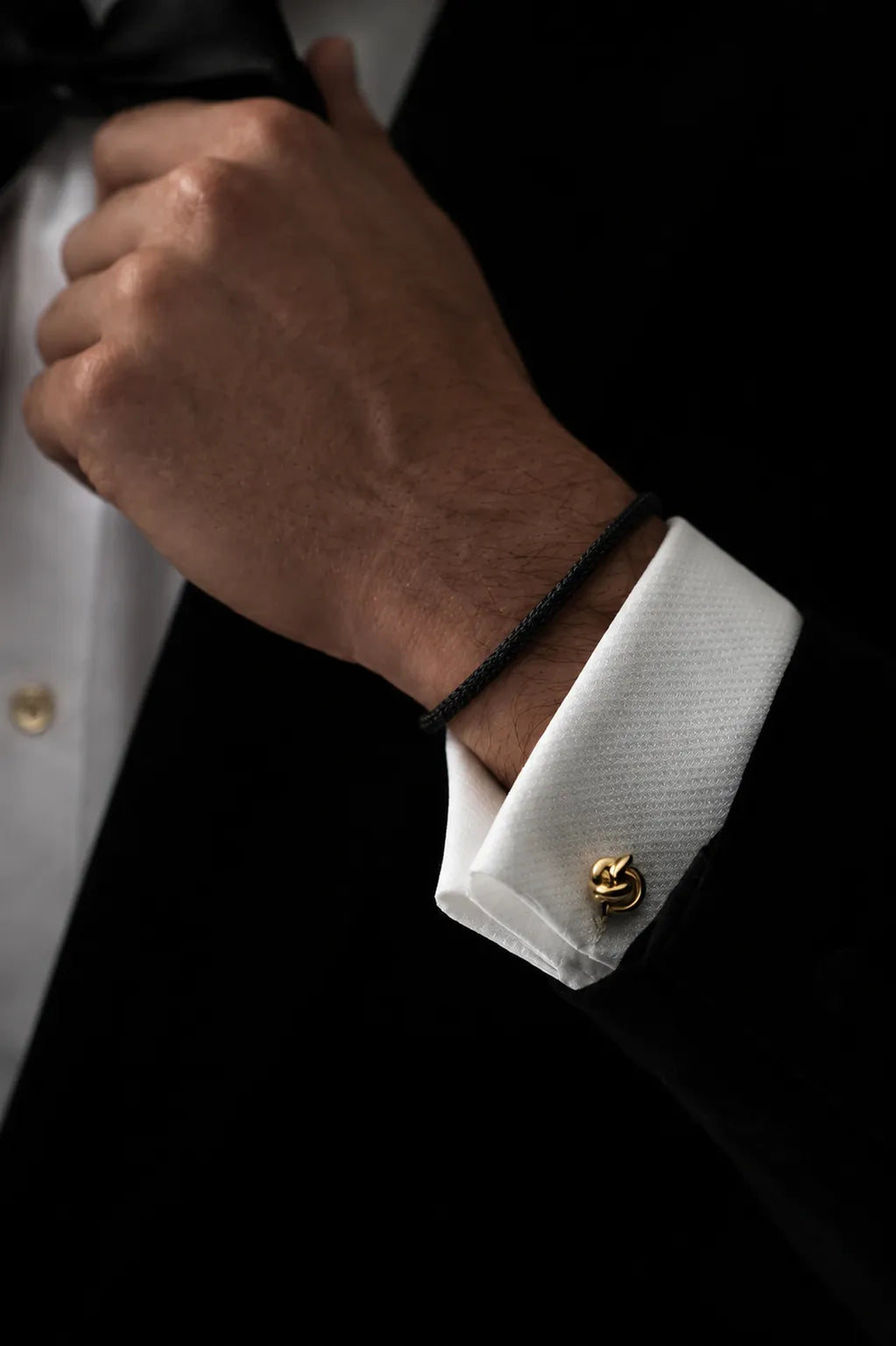 Pulseira Barcelona preta no pulso com terno e camisa branca