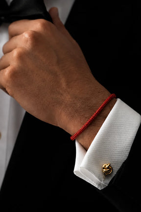 Pulseira Barcelona vermelha no pulso com terno e camisa branca